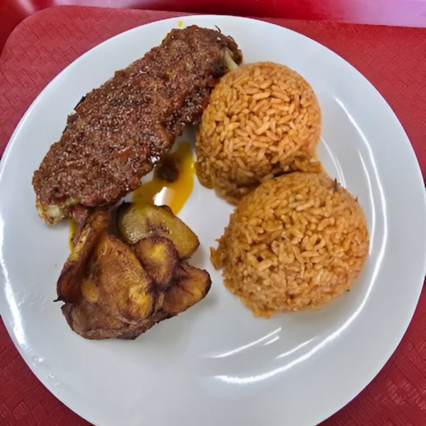 African cuisine plate with fried chicken, two scoops of jollof rice, and fried plantains.
